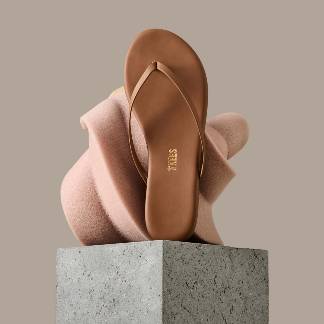 A beige flip flop on a pedestal