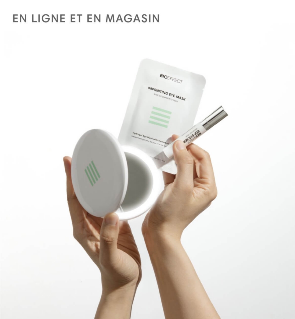 Une main tenant un miroir et deux autres produits Bioeffect