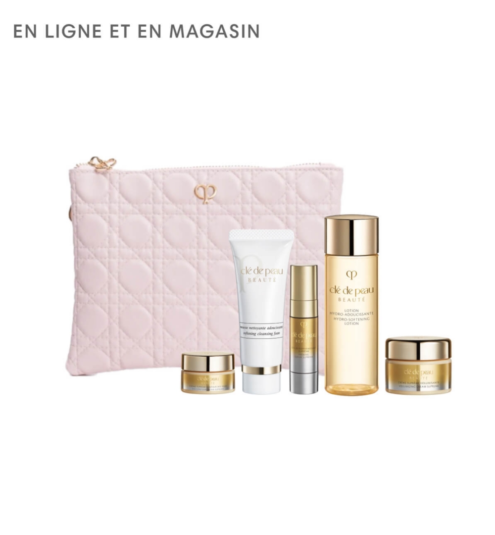 Une pochette rose clair entourée de produits de beauté Clé de Peau