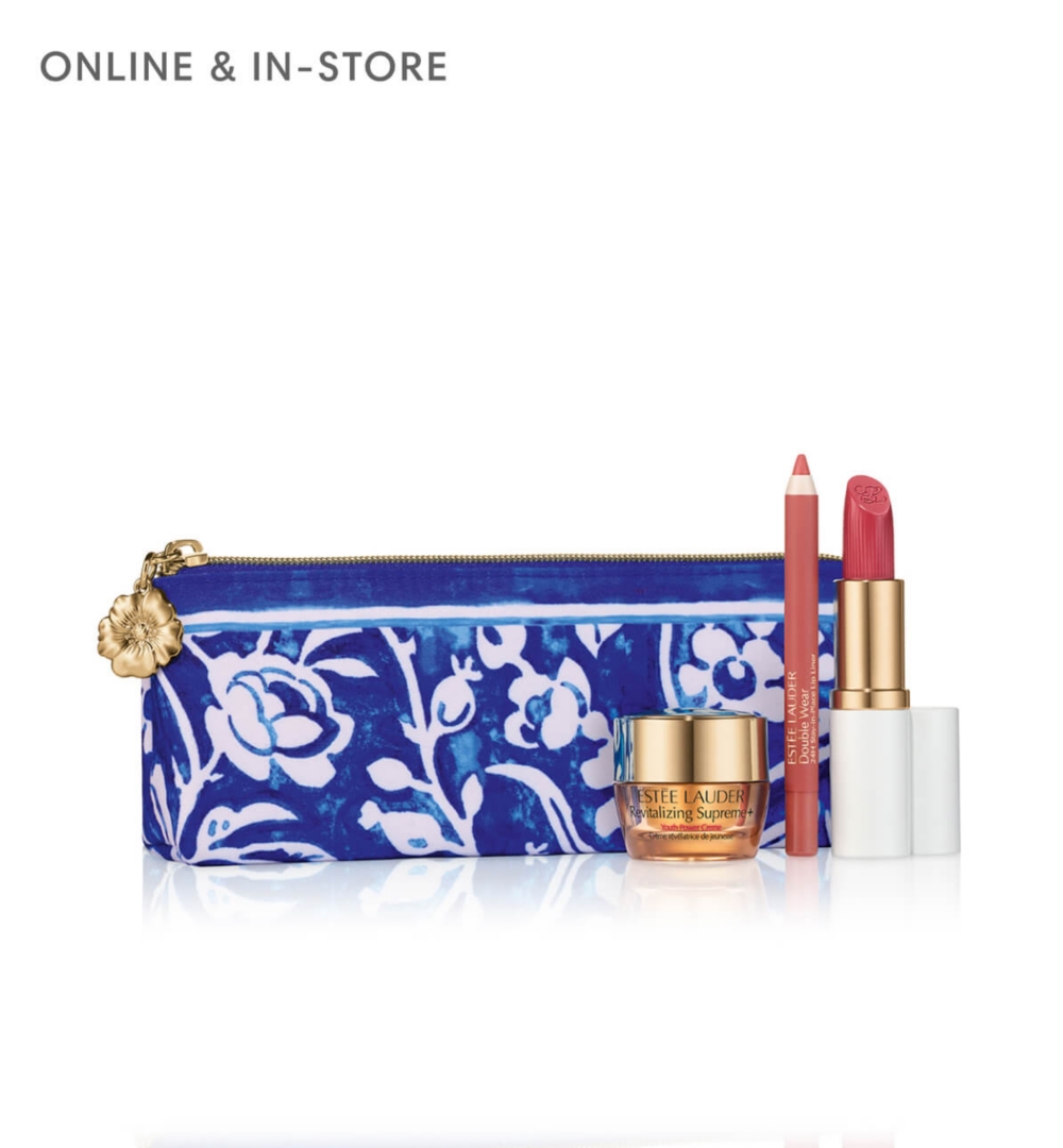 A blue floral patterned pouch surrounded by Estée Lauder products