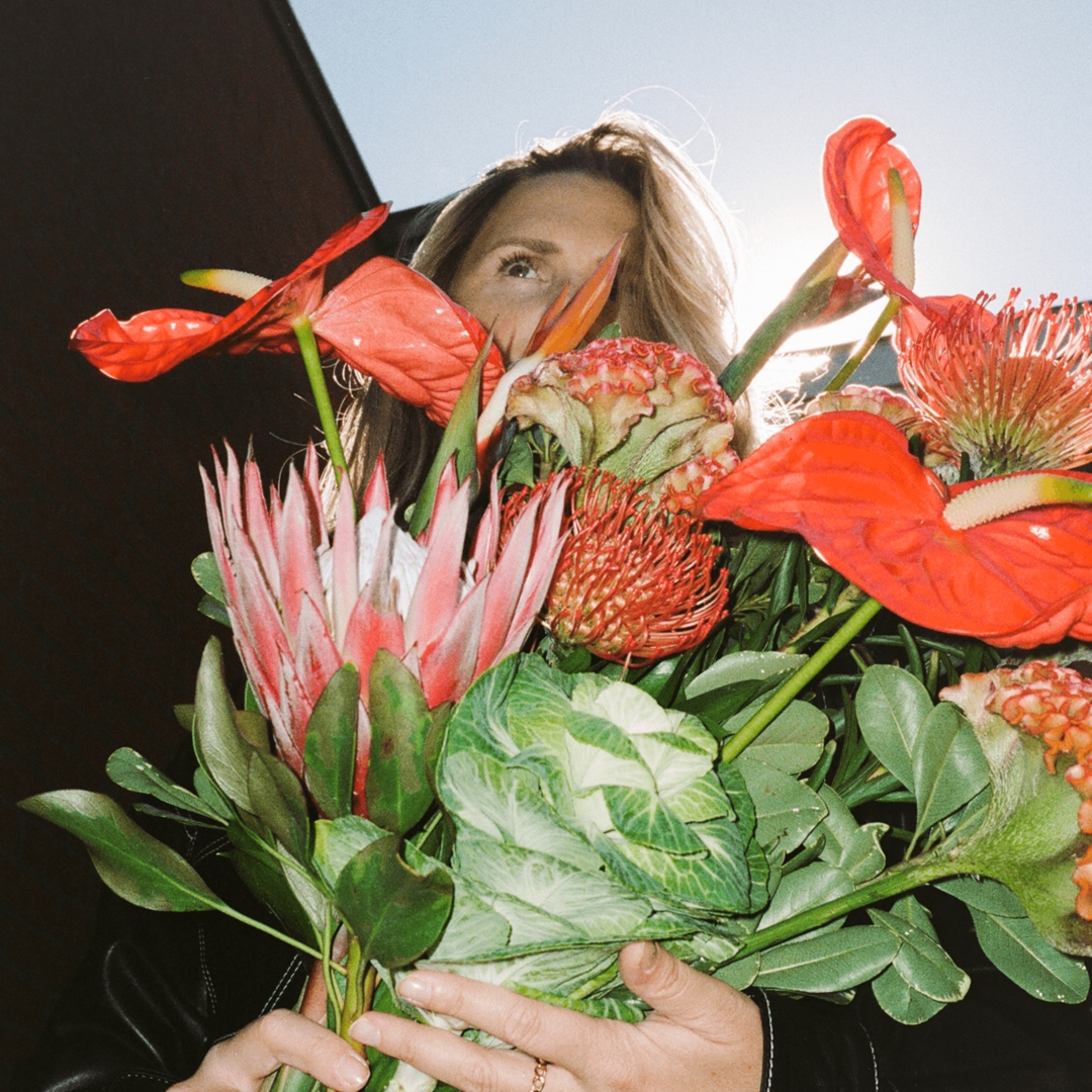 A model holding a beautiful bouquet of red flowers