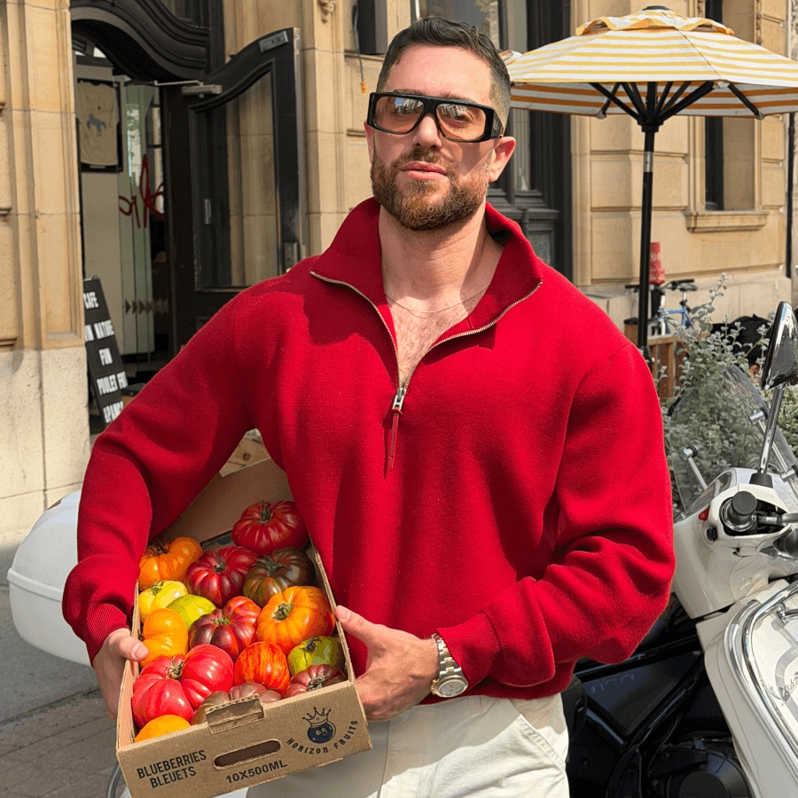 Michael Tozzi holds a basket of vibrant coloured tomatoes / Michael Tozzi tient un panier de tomates aux couleurs éclatantes.